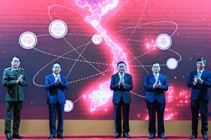 Thường trực Ban Bí thư Trần Cẩm Tú và các đại biểu thực hiện nghi thức ra mắt App TGDV trên điện thoại di động. (Ảnh: DUY LINH)