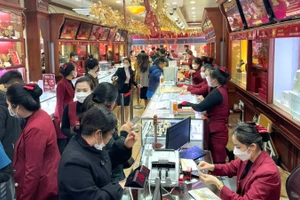 Người dân giao dịch mua vàng tại một cửa hàng trên phố Trần Nhân Tông (Hà Nội). (Ảnh: MINH PHƯƠNG)