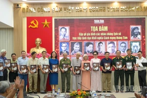 Tổng Biên tập Báo Nhân Dân Lê Quốc Minh trao những món quà tri ân tới các gia đình nhân chứng lịch sử. (Ảnh: THẾ ĐẠI)