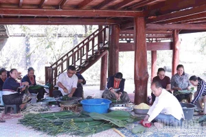 Gia đình Thượng tướng Souvon Leuangbounmi quây quần gói bánh chưng ngày Tết. (Ảnh: Duy Toàn)