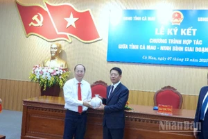 Bí thư Tỉnh ủy Cà Mau Nguyễn Hồ Hải (bìa trái) tặng quà lưu niệm cho đại diện tỉnh Ninh Bình tại lễ ký kết.