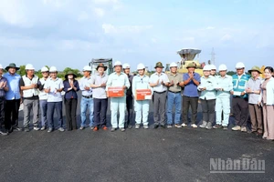 Bí thư Tỉnh ủy Nguyễn Hồ Hải và Chủ tịch Ủy ban nhân dân tỉnh Lữ Quang Ngời (cùng đội nón tai bèo có hình cờ Tổ quốc) tặng quà trên công trường cao tốc vào chiều 7/12.