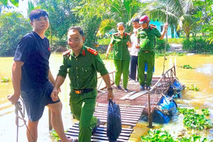 Tổ công tác lưu động Công an tỉnh Cà Mau không quản ngại điều kiện đi lại khó khăn tìm đến nhà từng hộ dân thu nhận mẫu ADN thân nhân liệt sĩ.