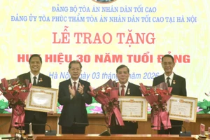 Chánh án Tòa án nhân dân tối cao Nguyễn Văn Quảng và ba đồng chí được trao Huy hiệu 30 năm tuổi Đảng.
