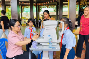 Bác sĩ khám mắt cho học sinh trong chương trình "Ngày thứ Bảy vì dân".