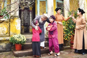 Nụ cười sum vầy của gia đình miền bắc với cành đào xuân là biểu tượng thiêng liêng của sự gắn kết và ấm áp trong ngày Tết cổ truyền.