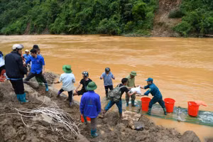 Ðoàn viên Ðoàn Thanh niên hỗ trợ bà con vùng lũ tại Mù Cang Chải (Lào Cai). (Ảnh THÀNH ĐẠT)