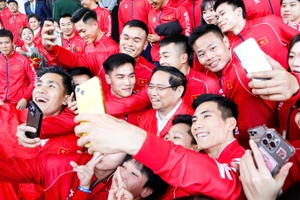 Thủ tướng Phạm Minh Chính trong trang phục thi đấu của Đoàn Thể thao Việt Nam tham dự SEA Games 33 chụp hình lưu niệm với các vận động viên.