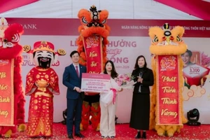 Ông Đỗ Đức Thành, Phó Tổng Giám đốc Agribank và Bà Nguyễn Thị Dung, Giám đốc Ngân hàng Nhà nước-Chi nhánh khu vực 6 trao giải cho khách hàng Bùi Thị Lan