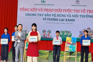 Ông Trần Xuân Tâm, Phó Giám giám đốc Quỹ Bảo vệ và Phát triển rừng tỉnh Điện Biên, trao giải Nhất cuộc thi cho em Mai Thùy Chi, lớp 8C1 Trường Trung học cơ sở Thanh Luông.