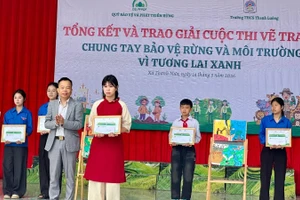 Ông Trần Xuân Tâm, Phó Giám giám đốc Quỹ Bảo vệ và Phát triển rừng tỉnh Điện Biên, trao giải Nhất cuộc thi cho em Mai Thùy Chi, lớp 8C1 Trường Trung học cơ sở Thanh Luông.