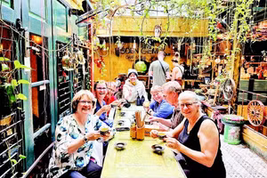 Du khách nước ngoài thích thú khi sử dụng các sản phẩm thân thiện với môi trường tại quán cà-phê Hidden Gem, Hà Nội.