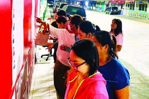 Công nhân Công ty TNHH Pouyuen Việt Nam tìm hiểu tiểu sử của các ứng cử viên được niêm yết tại khu vực nhà máy.