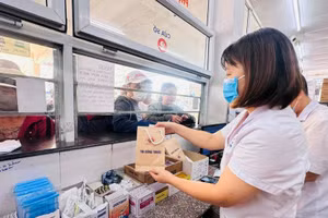 Nhân viên y tế cấp phát thuốc bảo hiểm y tế cho người bệnh. (Ảnh Thùy Giang)