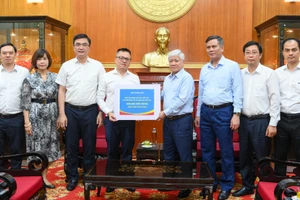 Tổng Biên tập Báo Nhân Dân Lê Quốc Minh trao số tiền quyên góp từ các cán bộ, phóng viên, nhân viên của báo ủng hộ đồng bào khắc phục hậu quả bão, lũ.