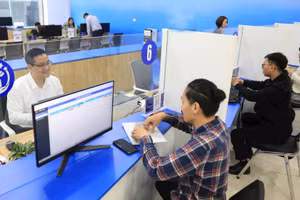 Hỗ trợ người dân giải quyết thủ tục hành chính trực tuyến tại Trung tâm Phục vụ hành chính công chi nhánh Tây Hồ. (Ảnh: QUANG PHONG)