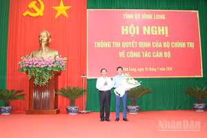 Đồng chí Nguyễn Mạnh Hùng nhận hoa chúc mừng của đồng chí Trần Văn Lâu, Ủy viên Trung ương Đảng, Bí thư Tỉnh ủy Vĩnh Long.