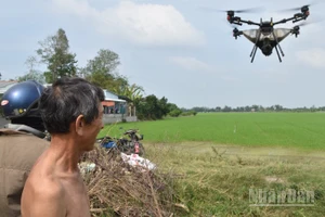 Một nông dân ở xã Mỹ Thành, tỉnh Đồng Tháp thuê máy bay không người lái (drone) để phun phân bón cho đồng ruộng.