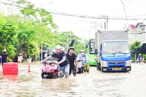 Triều cường gây ngập nặng tuyến đường Đào Sư Tích, xã Nhà Bè, làm đảo lộn cuộc sống của người dân. (Ảnh THẾ ANH)
