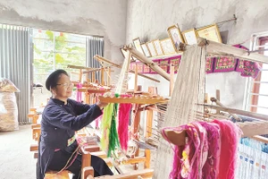Nghệ nhân Nông Thị Thược thực hành kỹ thuật dệt thổ cẩm. Ảnh: Văn Học 