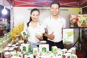 Anh Nguyễn Mạnh Tường, Giám đốc Hợp tác xã Nông nghiệp sạch Hatisa (bên phải) giới thiệu sản phẩm. Ảnh: Ngọc Khánh