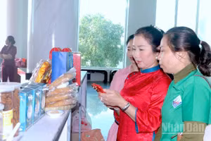 Khách hàng tham quan trưng bày sản phẩm OCOP bên lề hội nghị và trải nghiệm quét mã truy xuất nguồn gốc sản phẩm được in trên bao bì.