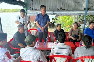 Phó Chủ tịch Ủy ban Mặt trận Tổ quốc Việt Nam tỉnh Cà Mau Nguyễn Văn Khởi (đứng, áo xanh) ân cần thăm hỏi các hộ dân có nhà bị cháy.