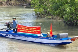 Cán bộ chạy xuồng đến tận những căn nhà ven sông để trao thẻ cử tri, mang lại niềm vui và sự an tâm cho bà con vùng sâu Cà Mau. 