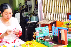 Chị Nguyễn Hồng Phúc cặm cụi từng chi tiết cho những mô hình “nhà xưa” thu nhỏ để lưu giữ ký ức tuổi thơ.