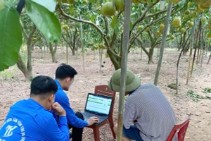 Cán bộ Đoàn Thanh niên xã Phúc Hòa (Tân Yên) hướng dẫn người dân cách đăng ký trên sàn thương mại điện tử. (Ảnh: NGUYỄN MIỀN)