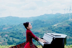 Hoa Ngọc Hà trong một chương trình ghi hình mới đây với trang phục áo dài chất liệu thổ cẩm của đồng bào Bru-Vân Kiều cùng cây đàn piano, tại quê nhà Khe Sanh. (Ảnh TRẦN TIẾN ĐẠT)