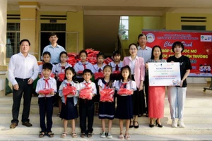 Đại diện Sở Giáo dục và Đào tạo tỉnh Đắk Lắk cùng nhà tài trợ trao tặng những phần quà Tết đến các em học sinh. (Ảnh: PV)