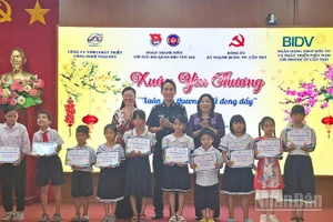 Bà Mã Thị Tươi (áo tím), Phó Chủ tịch Thường trực Hội đồng nhân dân thành phố Cần Thơ tặng học bổng cho các em học sinh.