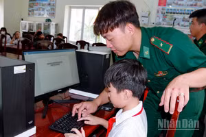 Cán bộ đồn Biên phòng Vĩnh Hải trực tiếp hướng dẫn các em thực hành trên máy tính.