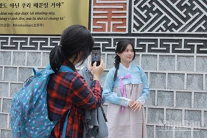 Các bạn trẻ thích thú chụp ảnh "check-in" trong trang phục Hanbok. 