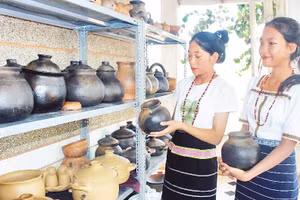 Thiếu nữ Chu Ru với sản phẩm gốm truyền thống.