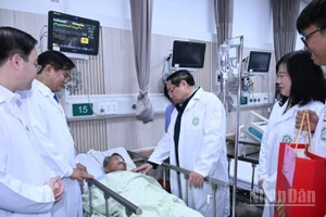 Thủ tướng Phạm Minh Chính thăm, tặng quà chúc Tết một bệnh nhân đang điều trị tại Trung tâm cấp cứu A9, Bệnh viện Bạch Mai. (Ảnh: Trần Hải)