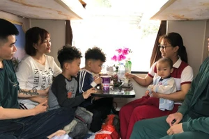 Gia đình chị Nguyễn Minh Thu, Nguyễn Thu Trang quây quần trong khoang tàu.