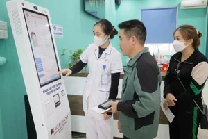 Ki-ốt tiếp nhận khám, chữa bệnh tự động phục vụ người dân khi đến đăng ký khám tại Trạm Y tế xã Sóc Sơn. (Ảnh THẢO TRẦN)