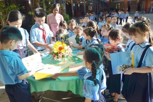 Học sinh Trường Tiểu học Kim Đồng, phường Rạch Giá tham khảo sách hướng dẫn sưu tập tem.