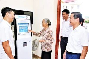 Cán bộ xã Đại Đồng hướng dẫn người dân làm thủ tục hành chính trên máy.