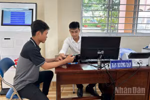Cán bộ Trung tâm Phục vụ hành chính công xã Mỹ Lợi hướng dẫn người dân thao tác nộp hồ sơ trực tuyến. 