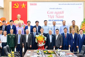 Các đại biểu chụp ảnh lưu niệm cùng tác giả Nguyễn Hồng Vinh tại Lễ ra mắt sách. (Ảnh: BẢO LONG)