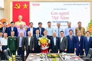 Các đại biểu chụp ảnh lưu niệm cùng tác giả Nguyễn Hồng Vinh tại Lễ ra mắt sách. (Ảnh: BẢO LONG)