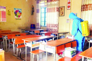 Thực hiện phun khử khuẩn tại trường học có học sinh mắc bệnh. (Ảnh PHƯƠNG THẢO)