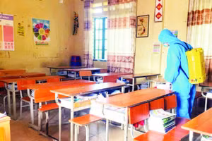 Thực hiện phun khử khuẩn tại trường học có học sinh mắc bệnh. (Ảnh PHƯƠNG THẢO)