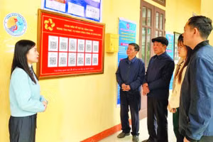 Cán bộ Trung tâm Phục vụ hành chính công xã Khoái Châu, tỉnh Hưng Yên hướng dẫn người dân quét mã QR để thực hiện thủ tục hành chính.