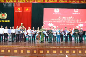 Đại tá Trần Bình Hưng, Phó Giám đốc Công an tỉnh Đắk Lắk và đại diện các sở, ngành tặng quà cho thân nhân các liệt sĩ tại chương trình.