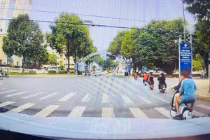 Nhóm học sinh điều khiển xe đạp điện không đội mũ bảo hiểm và vượt đèn đỏ gây mất an toàn giao thông giữa trung tâm phường Buôn Ma Thuột.