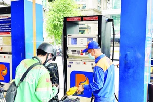 Người dân mua xăng sinh học E10 tại một điểm bán xăng dầu ở phường Xuân Hòa. (Ảnh HOÀNG LIÊM)